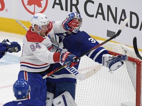 Toronto Maple Leafs goalie Jack Campbell (36) holds the puck in his glove as he is bodychecked by Montreal Canadiens forward Corey Perry earlier this season.