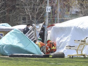 A Toronto Fire prevention officer, Toronto Police, and electricians were on hand at the south end of the tent city in Alexandra Park after electrical wiring from a park lamp post was being used to feed electricity inside part of a large white tent  on  April 27, 2021.