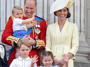 In this file photo taken on June 08, 2019 (L-R),  Britain's Prince William, Duke of Cambridge holding Prince Louis, Prince George, Princess Charlotte and Britain's Catherine, Duchess of Cambridge stand with other members of the Royal Family on the balcony of Buckingham Palace to watch a fly-past of aircraft by the Royal Air Force, in London . -
