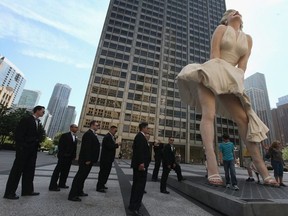 A wedding party looks at ” Forever Marilyn”, a sculpture by Seward Johnson, on July 15, 2011 in Chicago, Illinois.