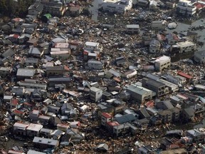 This file photo taken on March 12, 2011 shows collapsed houses and debris in a field in Kesennuma, Miyagi prefecture on March 12, 2011 after the massive 8.9-magnitude earthquake and tsunami hit Japan.
