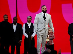 Drake, accompanied by his son Adonis, accepts the award for Artist of the Decade at the 2021 Billboard Music Awards outside the Microsoft Theater in Los Angeles, May 23, 2021.