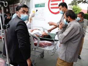 People transport an injured woman to a hospital after a blast in Kabul, Afghanistan May 8, 2021.