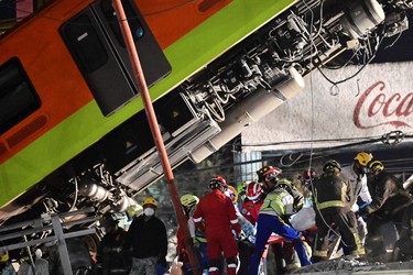 Rescue workers remove a body from a train carriage after an elevated metro line collapsed in Mexico City on May 4, 2021. (Photo by PEDRO PARDO/AFP via Getty Images)