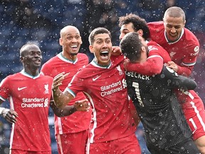 Liverpool goalkeeper Alisson Becker celebrates after scoring his team's second goal during an English Premier League game against West Bromwich Albion at The Hawthorns stadium in West Bromwich, central England, on May 16, 2021.