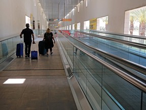 Departing passengers roll their suitcases at the nearly deserted Ben Gurion Airport in Lod, near the Israeli coastal city of Tel Aviv, on May 13, 2021.