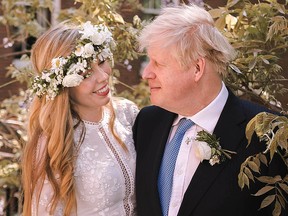 In this handout image released by 10 Downing Street, Prime Minister Boris Johnson poses with his wife Carrie Johnson in the garden of 10 Downing Street following their wedding at Westminster Cathedral, May 29, 2021 in London.