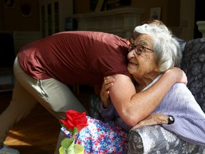 Community coordinator Terence Surin hugs Joan Brock, 101, who is a resident at Alexander House Care Home in Wimbledon, as COVID-19 restrictions continue to ease, London, May 17, 2021.