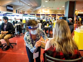 A health-care worker administers the Pfizer/BioNTech COVID-19 vaccine at Woodbine Racetrack pop-up vaccine clinic in Toronto, May 5, 2021.