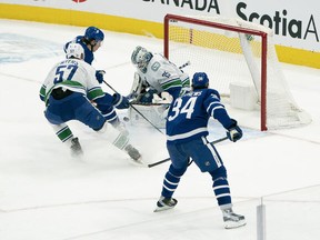 Maple Leafs forward Mitch Marner (16) is stopped by Vancouver Canucks goaltender Thatcher Demko on Saturday night in Toronto.