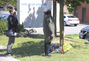 Two women drop off flowers at the shooting scene in Mississauga on Sunday, May 31, 2021. A 25-year-old man was shot dead. JACK BOLAND/TORONTO SUN