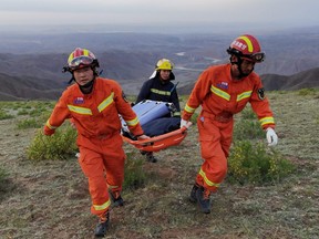 Rescue workers carry a stretcher as they work at the site where extreme cold weather killed participants of an ultramarathon race in Baiyin, Gansu province, China, on Saturday, May 22, 2021.