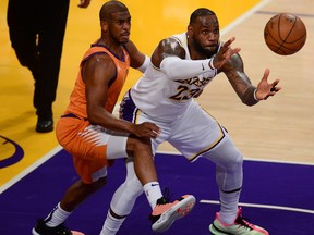 Los Angeles Lakers forward LeBron James, right, gets the ball against the defence of Phoenix Suns guard Chris Paul during the second half in Game 4 of the first round of the 2021 NBA Playoffs at Staples Center in Los Angeles, Calif., May 30, 2021.