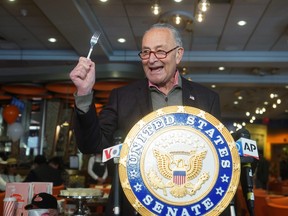 U.S. Senator Chuck Schumer holds up a fork at the official re-opening of Junior's restaurant in Times Square in the Manhattan borough of New York City, May 6, 2021.