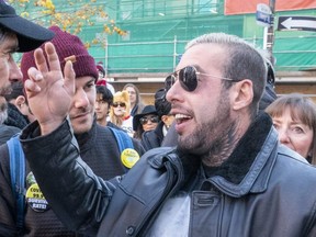 Anti-mask activist Chris Saccoccia, right, speaks to protesters at an anti-mask rally in Toronto on Saturday October 31, 2020.