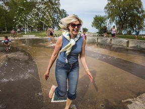 Mississauga Mayor Bonnie Crombie takes a run through the spray pad at Jack Darling Memorial Park in Mississauga, Ont. on Friday.