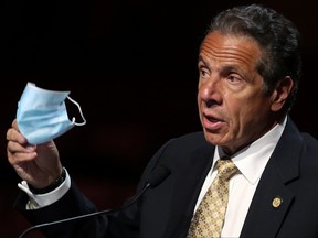 New York Governor Andrew Cuomo holds a protective mask as he speaks while making an announcement at a news conference from the stage at Radio City Music Hall in Manhattan in New York City, May 17, 2021.