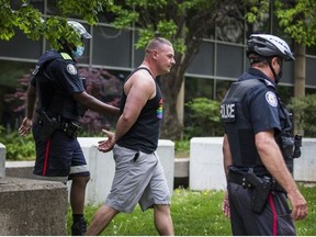 Police take a man into custody during a pop-up vaccine clinic at City Hall on Sunday.