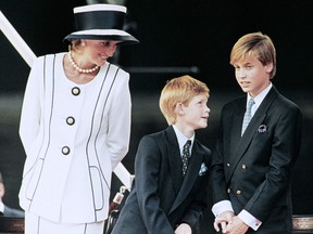 In this file photo taken on August 19, 1995 Princess Diana and their children William and Harry watch the march past on a dais on the mall as part of the commemorations of VJ Day.