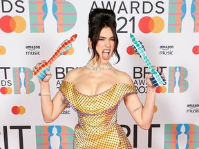 In a handout picture released by the Brit Awards, British singer-songwriter Dua Lipa poses with her awards for Female Solo Artist and British Album at the BRIT Awards 2021 in London on May 11, 2021.