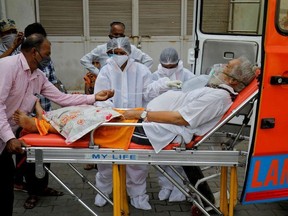 A patient wearing an oxygen mask is wheeled inside a COVID-19 hospital for treatment, amidst the spread of the coronavirus disease (COVID-19) in Ahmedabad, India, April 26, 2021.