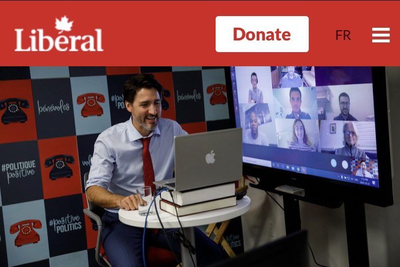 An image of Prime Minister Justin Trudeau on the Liberal Party website using a PC laptop with an Apple logo sticker.