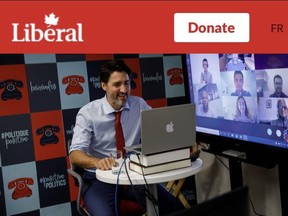 An image of Prime Minister Justin Trudeau on the Liberal Party website using a PC laptop with an Apple logo sticker.