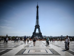 Tourists visit the Esplanade des Droits de l'Homme with the Eiffel Tower in the background, in Paris on August 6, 2020.