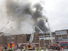 Firefighters and Toronto Police don respirators and masks as Toronto Fire battles a 6 alarm blaze at York Memorial Collegiate Institute in 2019.