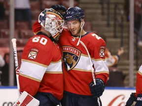 Florida Panthers goaltender Chris Driedger, left, and centre Alex Wennberg celebrate after winning the game against the Tampa Bay Lightning at BB&T Center in Sunrise, Fla., May 10, 2021.