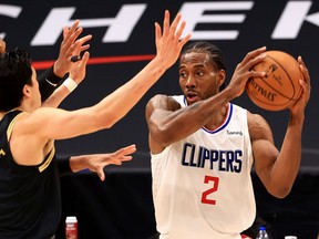 Former Raptors star Kawhi Leonard of the L.A. Clippers (right) looks to pass against the Raptors at Amalie Arena in Tampa, Fla., on May 11, 2021.