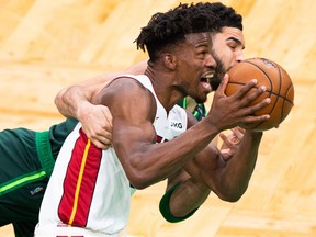Jimmy Butler, foreground, of the Miami Heat is fouled by Jayson Tatum of the Boston Celtics in the first half at TD Garden on May 11, 2021 in Boston, Mass.