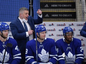 Toronto Maple Leafs head coach Sheldon Keefe speaks to his players as forward Pierre Engvall (47) and forward Jason Spezza (19) and forward Wayne Simmonds (24) listen during the third period against the Montreal Canadiens at Scotiabank Arena May 8, 2021.