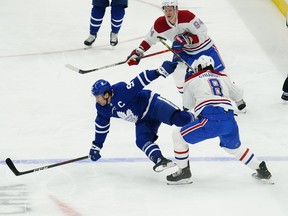 Toronto Maple Leafs forward John Tavares (91) is hit by Montreal Canadiens defenceman Ben Chiarot (8) before taking a knee by Corey Perry (94) during the first period of game one of the first round of the 2021 Stanley Cup Playoffs at Scotiabank Arena May 20, 2021.