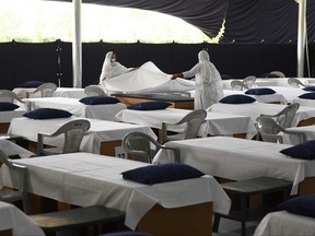Volunteers arrange beds made out of cardboard to be used by COVID positive patients as they convert a hall of a spiritual organization into a coronavirus care centre on the outskirts of Amritsar on May 22, 2021.