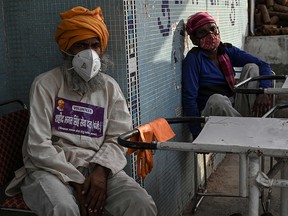 In this photograph taken on May 12, 2021 volunteers rest as they work at a crematorium in New Delhi amid the Covid-19 coronavirus pandemic.