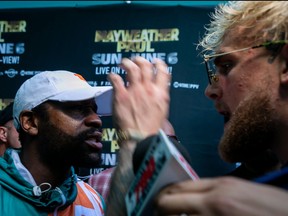 Floyd Mayweather, left, and Jake Paul confront each other during a press conference at Hard Rock Stadium, in Miami Gardens, Fla., on May 6, 2021.