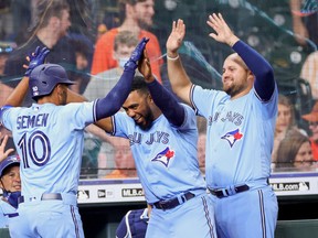 Marcus Semien of the Toronto Blue Jays celebrates with Teoscar Hernandez and Rowdy Tellez during Toronto's win over Houston on Saturday.