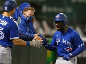 Pinch runner Jonathan Davis celebrates with his teammates after scoring a run  as the Blue Jays beat the Athletics on Wednesday night. GETTY IMAGES