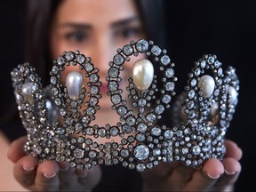 A staff holds a diamond and pearl tiara passed down through generations of the Italian royal family during a preview at Sotheby's before their auction in Geneva, Switzerland, May 6, 2021.