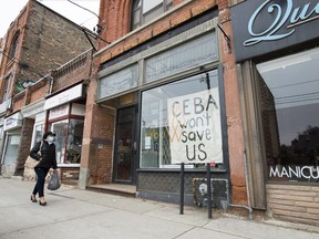 A closed store pleads for help by displaying a sign in Toronto on Thursday, April 16, 2020.