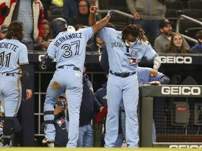 Blue Jays' Teoscar Hernandez (centre) celebrates with teammate Vladimir Guerrero Jr. after hitting a home run against the Braves during the seventh inning at Truist Park in Atlanta on Wednesday, May 12, 2021.