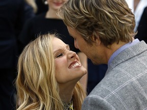 Kristen Bell kisses Dax Shepard while walking the red carpet for The Judge during the Toronto International Film Festival in Toronto on September 4, 2014.