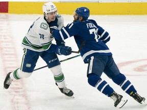 Vancouver Canucks right wing Kole Lind battles with Toronto Maple Leafs winger Nick Foligno at Scotiabank Arena last night. USA TODAY SPORTS
