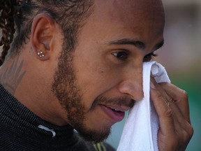 Mercedes' driver Lewis Hamilton cleans his face after the qualifying session at the Circuit de Catalunya on May 8, 2021 in Montmelo.