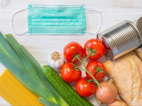 Donations food, vegetables, bread, pasta, canned food, and medical protective mask on wooden background. Help of generous people. Donate concept. Flat lay, copy space