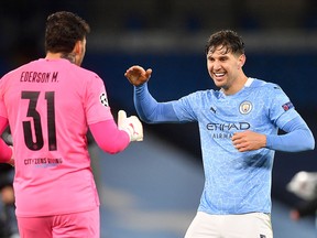 Manchester City goalkeeper Ederson (left) and defender John Stones celebrate after winning the UEFA Champions League semifinal against Paris Saint-Germain (PSG) at the Etihad Stadium in Manchester, May 4, 2021.