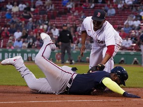 Atlanta Braves left fielder Marcell Ozuna (bottom) is tagged out at third base by Boston Red Sox third baseman Rafael Devers (top) at Fenway Park.