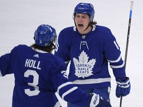 Maple Leafs forward Mitch Marner (16) celebrates with defenceman Justin Holl (3) after scoring against the Montreal Canadiens at Scotiabank Arena.