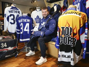 Mark Fera sits with some of the items from his extensive Auston Matthews collection that includes jerseys, gloves, pucks and helmets.